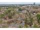 Aerial view of a wooded community showing mature trees, buildings, parking, and city skyline at 3080 Colony Rd # A, Durham, NC 27705