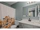 Bright bathroom featuring a quartz countertop vanity, mirror, and a colorful shower curtain at 3080 Colony Rd # A, Durham, NC 27705