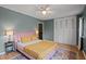 Bedroom with yellow quilt, rug, ceiling fan, and closet at 3080 Colony Rd # A, Durham, NC 27705