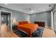 Comfortable bedroom with an orange bedspread, ceiling fan, and plenty of storage at 3080 Colony Rd # A, Durham, NC 27705