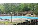 Community pool surrounded by lounge chairs and lush trees at 3080 Colony Rd # A, Durham, NC 27705