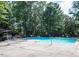 Community pool with lounge chairs surrounded by lush trees at 3080 Colony Rd # A, Durham, NC 27705