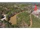 Aerial view of a neighborhood near a pond surrounded by lush greenery and mature trees at 3103 Woodland Park Rd, Durham, NC 27703