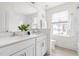 Bright bathroom featuring dual sinks, white cabinets, and a window at 3103 Woodland Park Rd, Durham, NC 27703