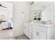 Bright bathroom featuring dual sinks, white cabinets, and wood-look vinyl flooring at 3103 Woodland Park Rd, Durham, NC 27703