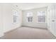 Bright bedroom featuring three windows and neutral carpet at 3103 Woodland Park Rd, Durham, NC 27703