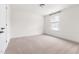 An empty bedroom with neutral carpet, white walls, and natural light from a window at 3103 Woodland Park Rd, Durham, NC 27703