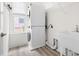 Efficient laundry room with stacked washer and dryer, sink, and storage shelves at 3103 Woodland Park Rd, Durham, NC 27703