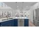 Open kitchen with a blue island featuring a stainless steel dishwasher and white countertops at 315 Barthel Dr, Cary, NC 27513