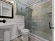 This renovated bathroom features a modern vanity, new lighting, and glass shower doors at 317 Gary St, Raleigh, NC 27606