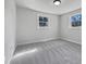 This bedroom boasts natural light with two windows and neutral carpeting throughout at 317 Gary St, Raleigh, NC 27606