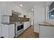 This updated kitchen features white cabinets, stainless steel appliances, and mosaic tile backsplash at 317 Gary St, Raleigh, NC 27606