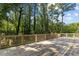 Inviting wood deck with railing, surrounded by lush trees and bright blue sky views at 3605 Octavia St, Raleigh, NC 27606