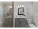 Modern bathroom with gray vanity, quartz countertop, stylish mirror, and walk-in shower with glass door at 3605 Octavia St, Raleigh, NC 27606