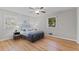 This bedroom features hardwood floors, ceiling fan and a comfortable bed with white and gray bedding at 3605 Octavia St, Raleigh, NC 27606