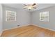 Empty bedroom showcasing hardwood floors, a ceiling fan, and two windows for plenty of natural light at 3605 Octavia St, Raleigh, NC 27606