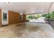 Attached carport featuring brick wall, door, window, and well-lit paved driveway at 3605 Octavia St, Raleigh, NC 27606