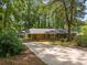 One-story brick house with long driveway and covered carport surrounded by mature trees at 3605 Octavia St, Raleigh, NC 27606