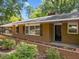 Charming brick home featuring an inviting entrance, windows with shutters, and a landscaped garden bed at 3605 Octavia St, Raleigh, NC 27606