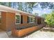 Brick home with white trim and black shutters with a flower bed at 3605 Octavia St, Raleigh, NC 27606