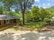 View of a brick house's front yard, with trees providing shade and a healthy lawn at 3605 Octavia St, Raleigh, NC 27606