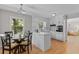 Well-lit eat-in kitchen with a glass table and white cabinets, perfect for meals and gatherings at 3605 Octavia St, Raleigh, NC 27606