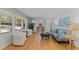 Bright living room with hardwood floors, a gray couch, and large windows that let in natural light at 3605 Octavia St, Raleigh, NC 27606