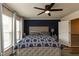 Bedroom features a ceiling fan, an upholstered headboard, and natural light from the windows at 372 White Oak Ridge Dr, Garner, NC 27529