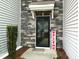 Close-up of stylish front door with stone surround and decorative welcome sign at 372 White Oak Ridge Dr, Garner, NC 27529