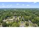 An aerial view of a neighborhood full of mature trees with the city skyline in the distance at 401 Fletcher Dr, Raleigh, NC 27603