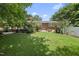 Expansive backyard featuring a lush green lawn, mature trees, and a brick exterior for private outdoor enjoyment at 401 Fletcher Dr, Raleigh, NC 27603