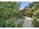 A tranquil backyard retreat features a charming covered patio, lush gardens and a stone creek pathway at 401 Fletcher Dr, Raleigh, NC 27603