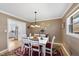 Bright dining room with white table set for six, hardwood floors, and neutral wall paint at 401 Fletcher Dr, Raleigh, NC 27603