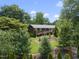 A classic brick home with a well-manicured lawn and landscaping, nestled among mature trees on a sunny day at 401 Fletcher Dr, Raleigh, NC 27603