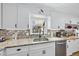 Charming kitchen boasts white cabinets, granite countertops, and modern stainless steel appliances at 401 Fletcher Dr, Raleigh, NC 27603