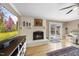 Cozy living room with a painted brick fireplace and hardwood floors and sliding door to deck at 401 Fletcher Dr, Raleigh, NC 27603