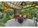 Outdoor patio featuring a roof, fan, seating, fire pit and lush green trees in the background at 401 Fletcher Dr, Raleigh, NC 27603