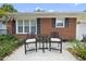 Inviting front patio with seating area, complemented by beautiful brickwork and landscaping, offers a relaxing outdoor space at 401 Fletcher Dr, Raleigh, NC 27603