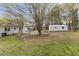 An exterior view of a well-manicured yard with storage building and mature trees at 409 Avery St, Garner, NC 27529