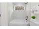 Modern bathroom featuring a combination shower and tub, window, and plants at 409 Avery St, Garner, NC 27529