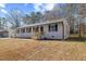 An eye-level view of a home with black window shutters, gray roof, and wood front steps at 409 Avery St, Garner, NC 27529