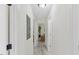 Hallway leading to a sunlit living area with gray luxury vinyl flooring and white walls at 409 Avery St, Garner, NC 27529