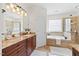 Luxurious bathroom with a soaking tub, glass shower, dual sinks, and granite countertops at 5300 Mandrake Ct, Raleigh, NC 27613