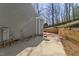 Side view of a grey house with a concrete patio, retaining wall, and a basketball hoop in the backyard at 6008 Chittim Ct, Raleigh, NC 27616