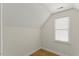 Small bedroom with hardwood floors, white walls, an angled ceiling, and window with blinds at 6008 Chittim Ct, Raleigh, NC 27616