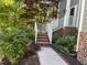 Charming brick stairs with white railing lead to front door and a beautifully landscaped yard at 6008 Chittim Ct, Raleigh, NC 27616