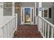 Charming covered front porch with classic brick stairs and white railing at 6008 Chittim Ct, Raleigh, NC 27616