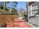 A red brick patio beside a grey home featuring a basketball hoop and bordered by a wood retaining wall at 6008 Chittim Ct, Raleigh, NC 27616