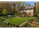 An expansive backyard featuring a lush lawn, a patio with outdoor seating, and a charming swing set at 609 Brookview Dr, Chapel Hill, NC 27514