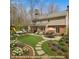 A beautifully landscaped backyard boasts a curved stone path, lush lawn, and an inviting outdoor seating area at 609 Brookview Dr, Chapel Hill, NC 27514
